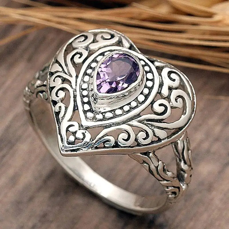 Silver vintage heart ring featuring a purple cubic zirconia stone set in an ornate filigree design.