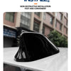 A black sleek shark fin antenna cover is shown resting on a white surface.