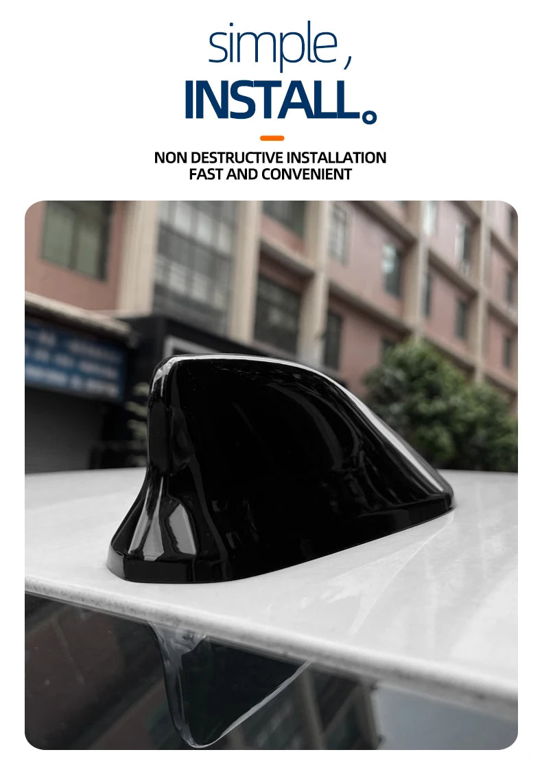 A black sleek shark fin antenna cover is shown resting on a white surface.