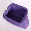 A purple hand-knit clutch bag with a textured surface and pearl accents.