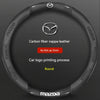 Black carbon fiber and leather steering wheel cover with a silver Mazda logo printing process