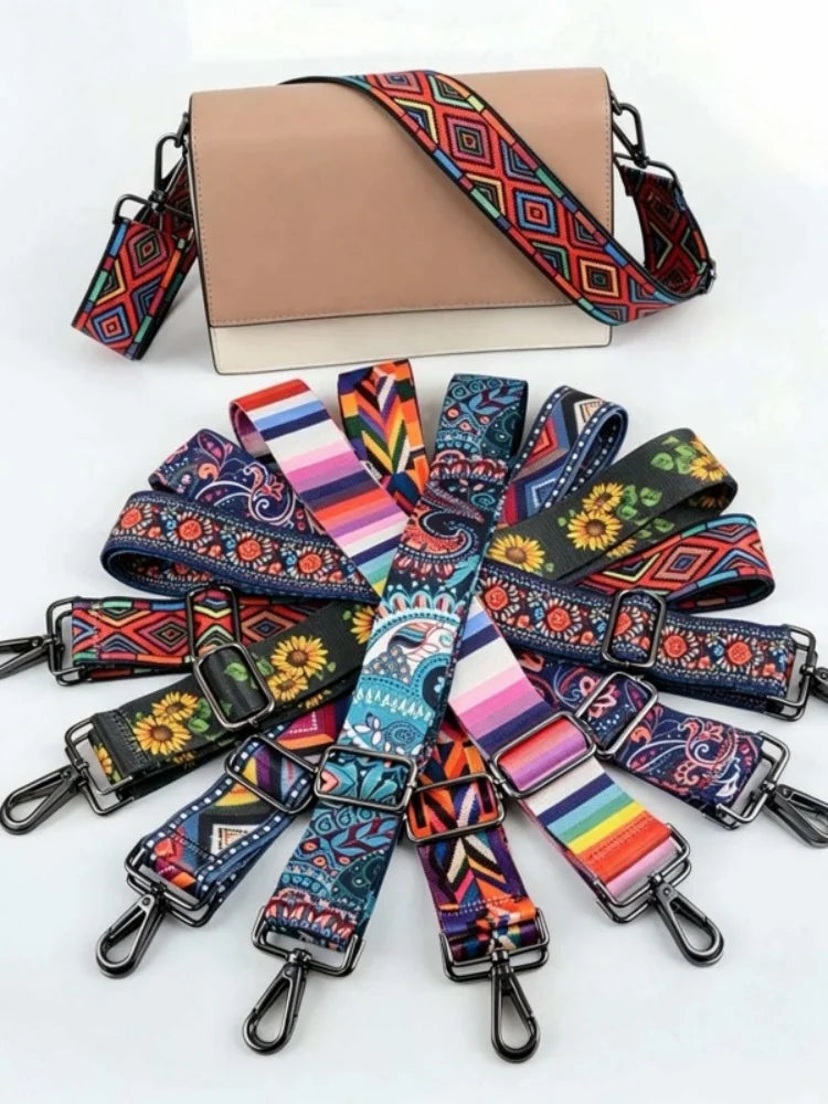 A beige crossbody bag with a patterned strap featuring geometric designs in red, orange, and blue.
