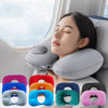 A collection of inflatable U-shaped travel neck pillows in various colors and shapes displayed next to a woman using one.