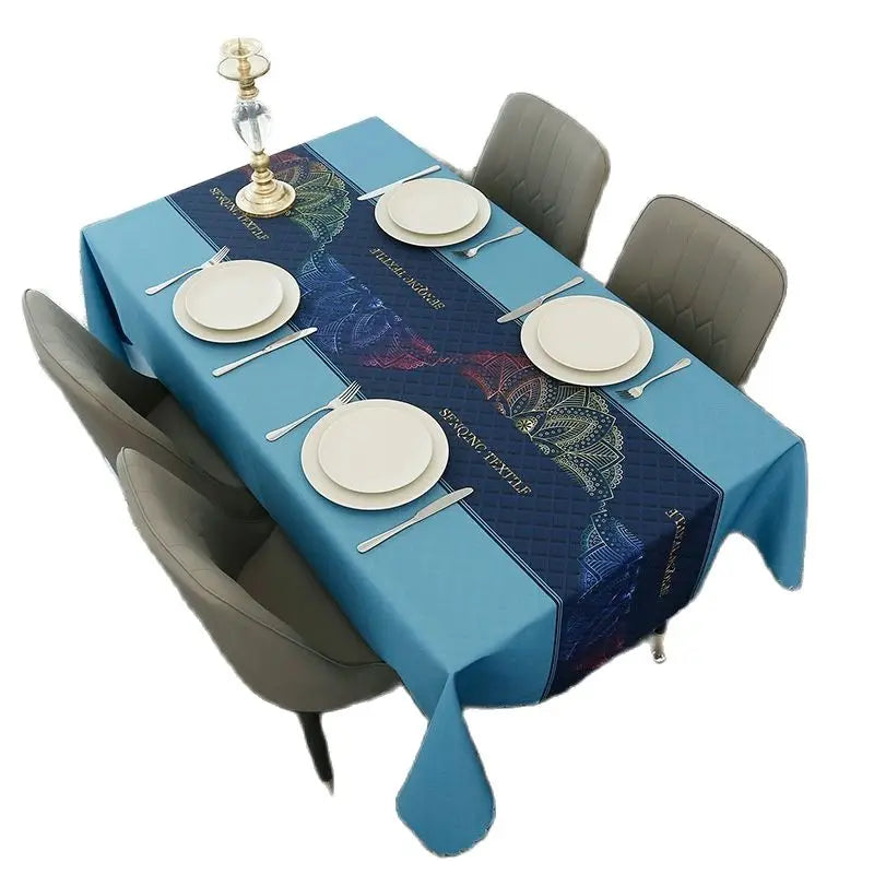 A blue geometric waterproof tablecloth set for a dining table with place settings and a candlestick.