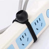 Close-up of a black bungee cord with an elastic ball end attached to a white strap.