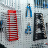 A white pegboard displaying various tools, including red and silver wrench organizers and pliers.