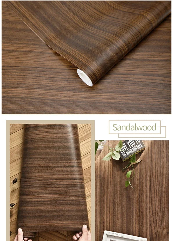 Roll of brown sandalwood wood grain wallpaper showing texture and application on a wooden surface.