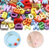Nahaufnahme gemischter Buchstaben-Spacerperlen in verschiedenen Farben und Formen für DIY-Bastelarbeiten.
