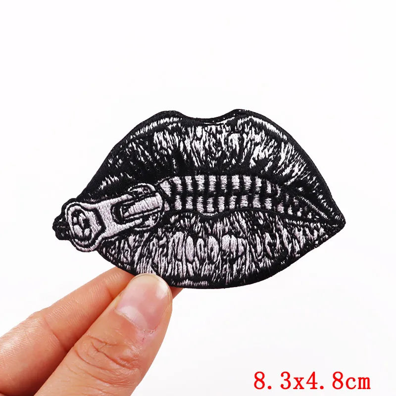 Black embroidered rose skull patch with iron-on backing shown being held by a hand