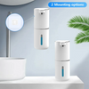 A white touchless automatic soap dispenser with blue accents is shown mounted on a wall above a sink and a countertop.