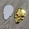 A shiny gold chrome skull emblem badge is shown next to a white silhouette of a human head.