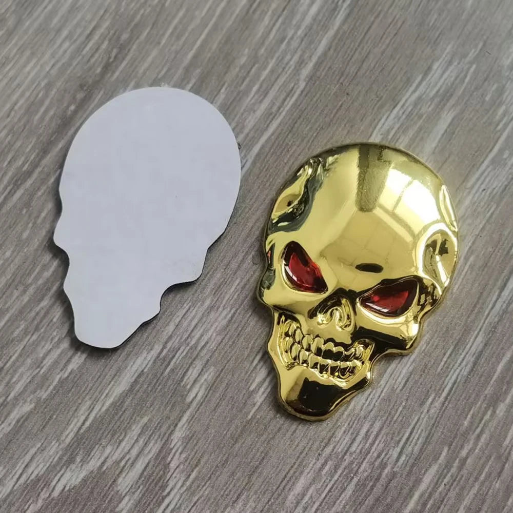 A shiny gold chrome skull emblem badge is shown next to a white silhouette of a human head.