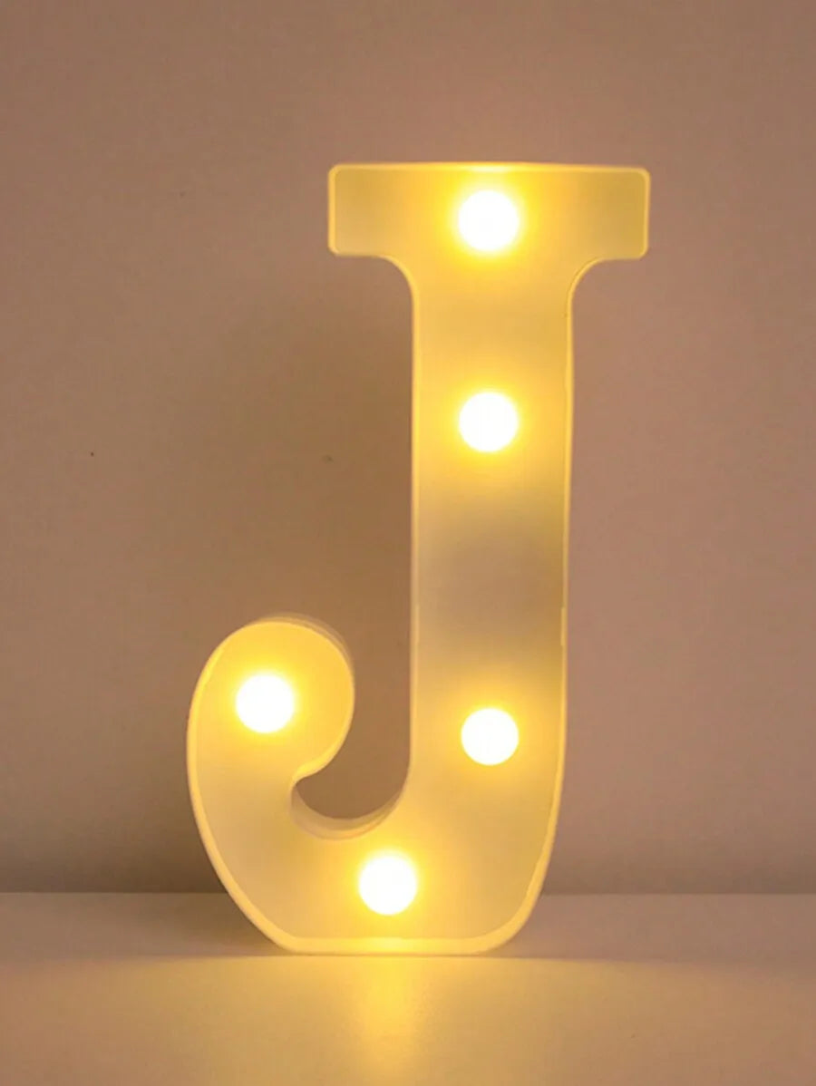 A glowing yellow LED letter J night light with multiple illuminated dots.