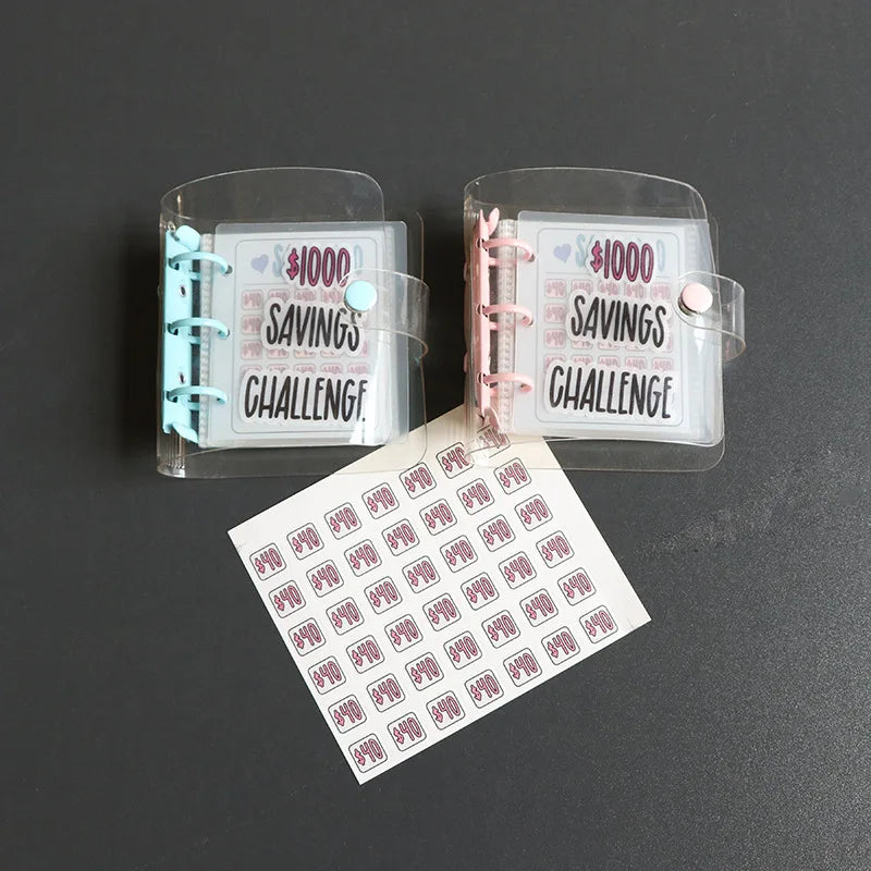 Zwei klare Plastikhüllen mit der Aufschrift "$1000 Savings Challenge", mit einem weißen Blatt darin.