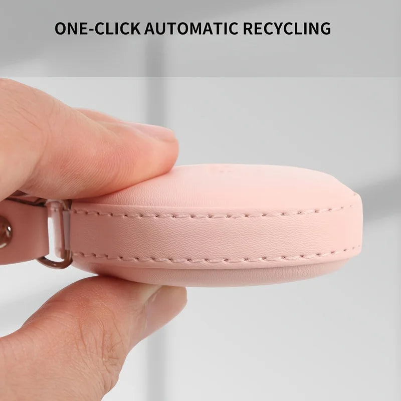 A hand holds a pink PU leather tape measure, demonstrating one-click automatic recycling.