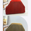 Primer plano de un bolso de mano tejido a crochet rojo con patrón chevron negro.