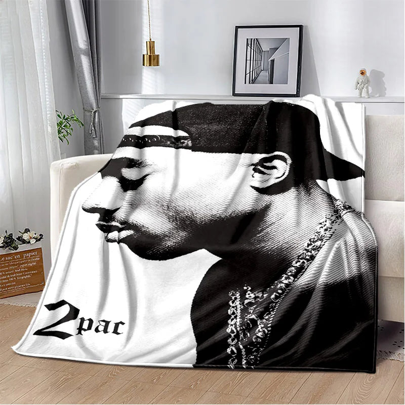 A throw blanket featuring a black and white portrait of Eminem and 2Pac.