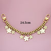 Gold chain phone strap featuring small white flower charms against a pink background.