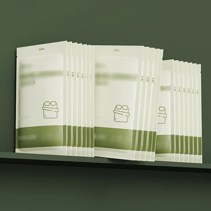 Un ensemble de draps pour lit jumeaux jetables emballés dans des gaines en plastique transparent sur une étagère sombre.