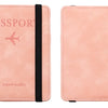 A pink leather passport wallet with a black strap and the word passport printed on the cover.