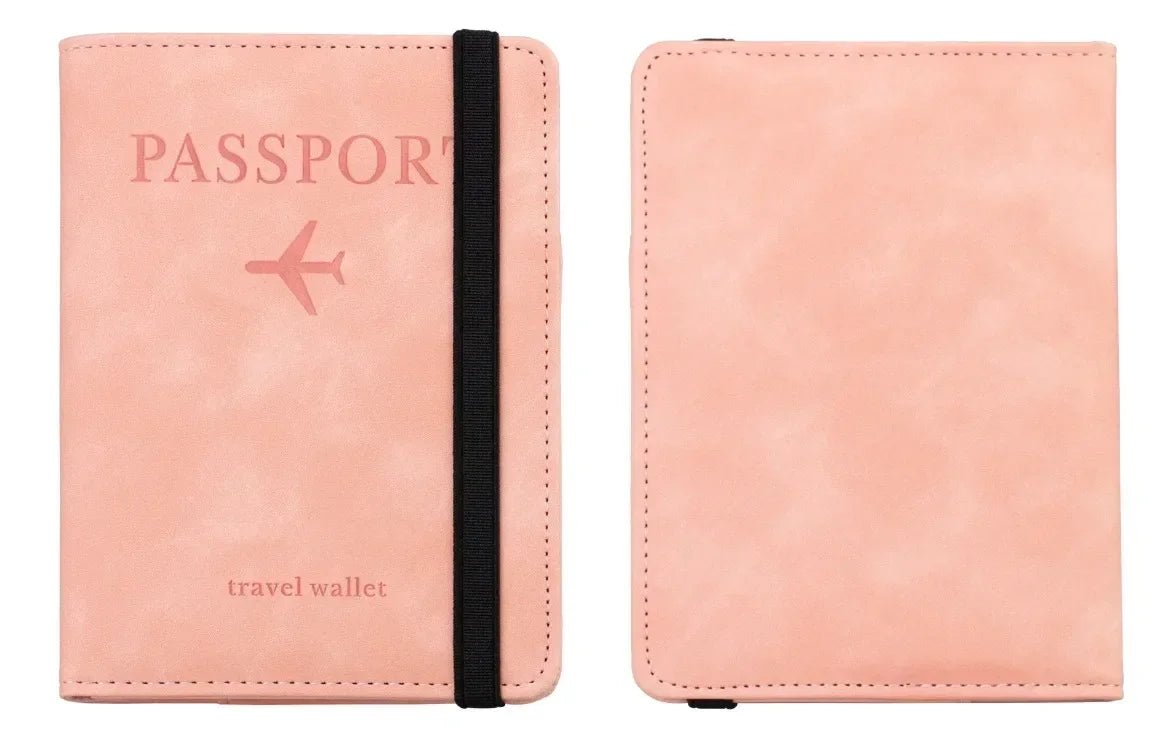 A pink leather passport wallet with a black strap and the word passport printed on the cover.