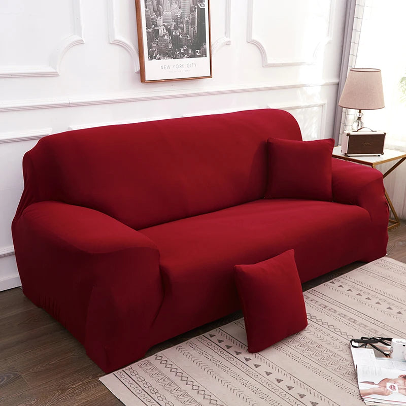 A deep red silky soft stretchable sofa cover displayed on a living room sofa.