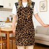 A woman models a brown and black leopard print kitchen apron over a white shirt in a bright kitchen setting.