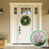 A white door with glass panels decorated with a green floral wreath, featuring heavy-duty transparent suction cup hooks.