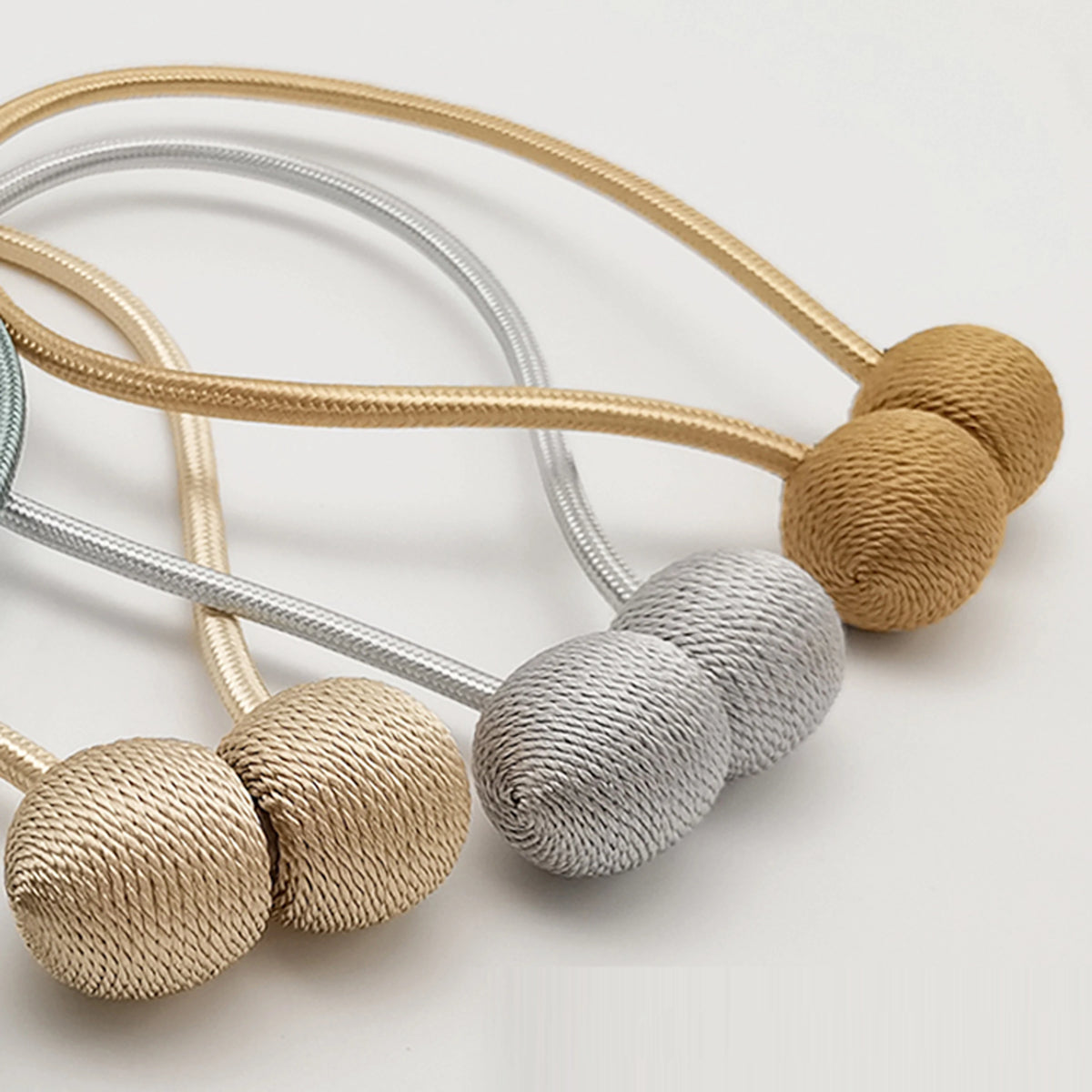 Un ensemble de pinces à rideaux magnétiques minimalistes en or, argent et beige.
