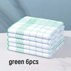 A stack of six green and white checkered lint-free dish cloths on a white surface.
