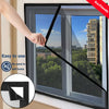 A hand is installing a black self-adhesive window mosquito net screen onto a window frame.