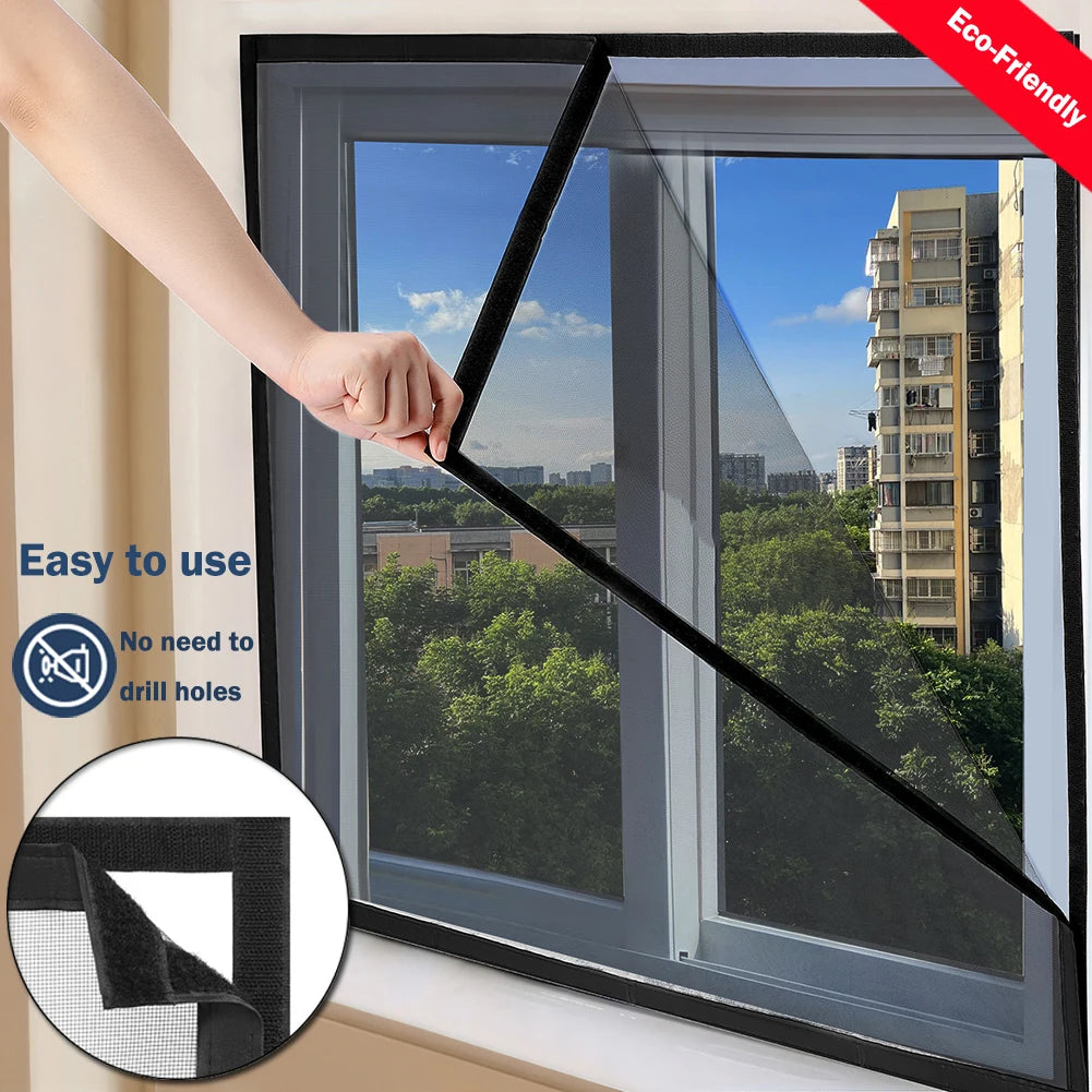A hand is installing a black self-adhesive window mosquito net screen onto a window frame.