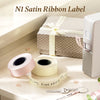Rolls of satin ribbon labels for an N1 label printer displayed on a white surface.