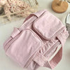 A light pink travel makeup bag with a wide opening is shown on a white surface.