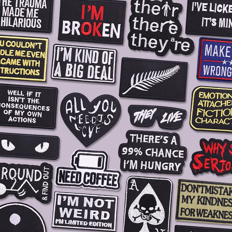A collection of black and yellow embroidered iron-on letter patches with various text designs.