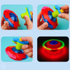 Colorful glowing musical spinning tops being held by hands, showing various colors and spinning motion.