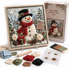 A box and framed piece of 3D fabric poke art depicting a winter scene with a snowman and evergreen trees.