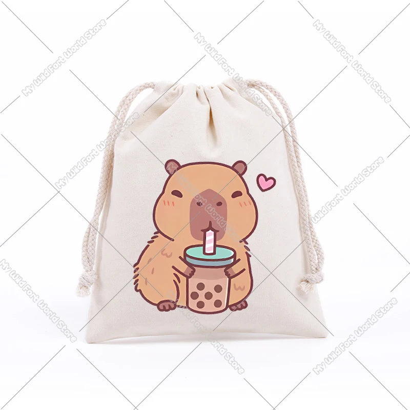 A beige drawstring storage bag featuring a cute, illustrated capybara holding a pink drink.