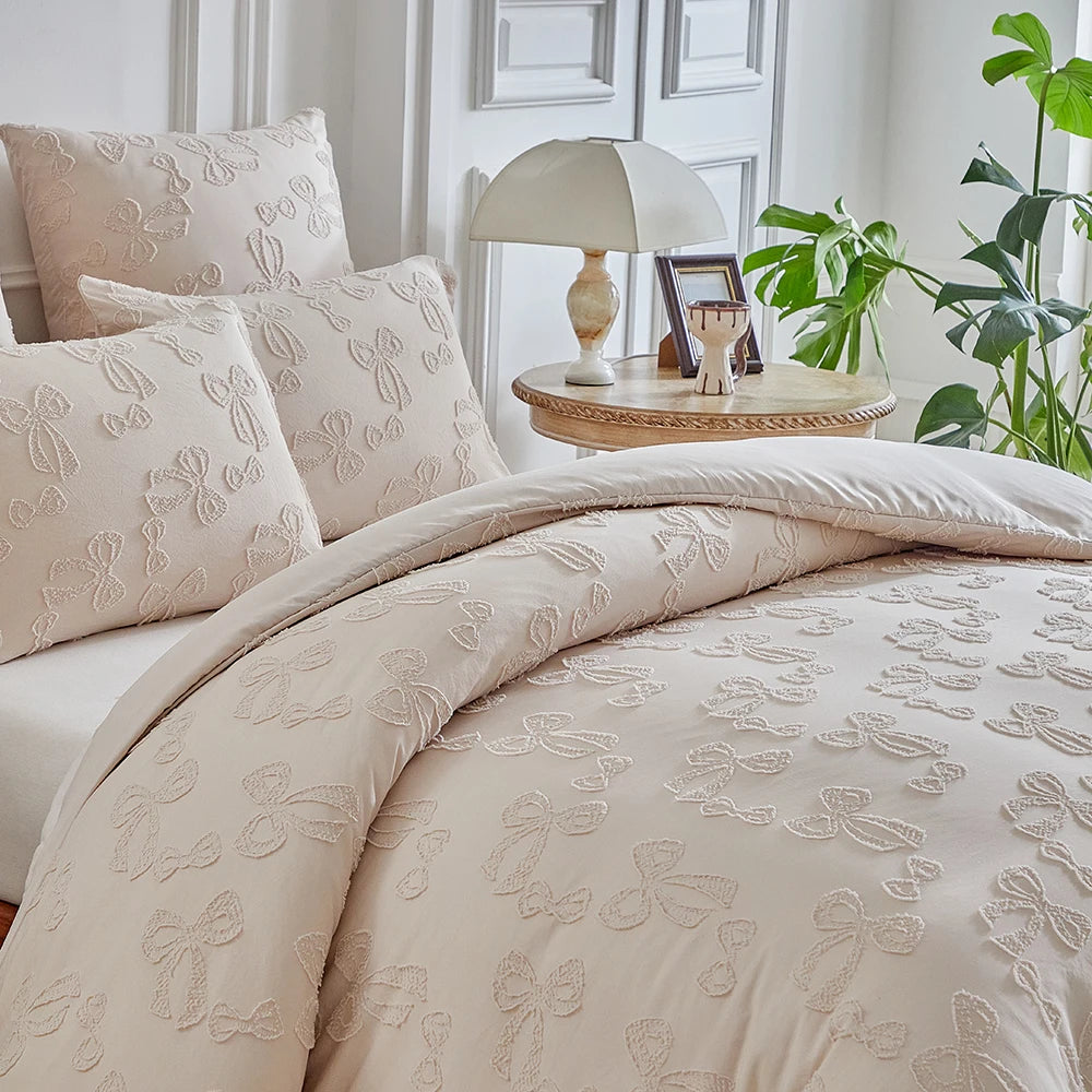 A beige duvet cover set with a delicate leaf print pattern displayed on a bed.