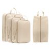 A set of five beige compressible packing cubes with fabric handles arranged in a row and a single cube.