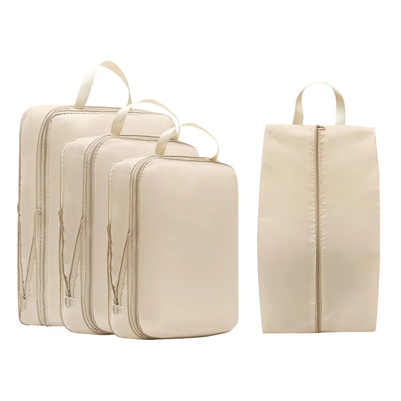 A set of five beige compressible packing cubes with fabric handles arranged in a row and a single cube.