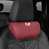 A red memory foam neck pillow is placed on a black car seat headrest.