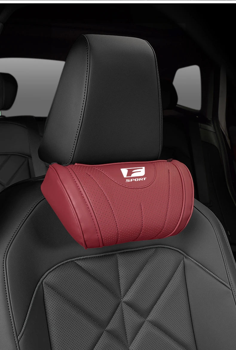 A red memory foam neck pillow is placed on a black car seat headrest.