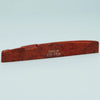 A wooden acoustic guitar bridge saddle with the inscription Guykər ATR-7630