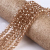 A strand of faceted crystal glass spacer beads is wrapped around a cylindrical object.