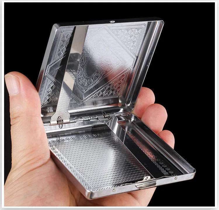 A hand holds open a classic stainless steel cigarette case with an embossed pattern.