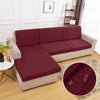 A deep burgundy waterproof sofa cushion cover with an elastic edge placed on a beige sofa.