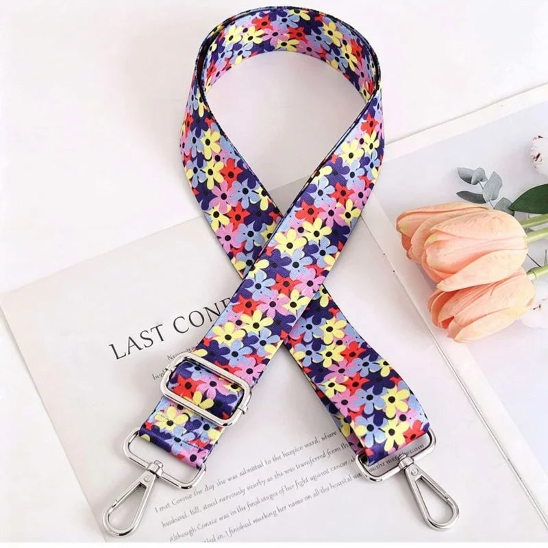 A floral patterned fabric strap for an elegant crossbody bag, shown against a white background.