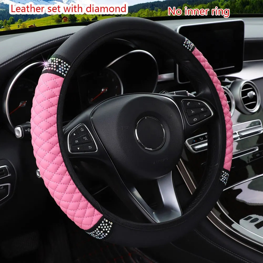 Pink faux leather steering wheel cover with diamond accents installed in a car interior.