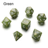 A set of green polyhedral dice, including a d6 and d10, scattered on a white surface.